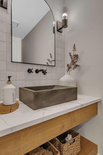 A charming main-level half bath featuring stylish finishes and thoughtful details, adding both convenience and character to the home.