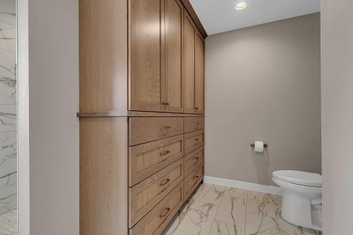 Thoughtfully designed custom cabinetry in the primary bath provides additional storage while keeping everything organized, accessible, and beautifully tucked away.