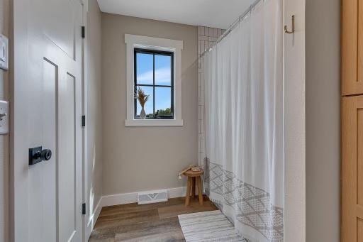 A look at the shared full bath and shower area, thoughtfully positioned between the two private vanity spaces of the Jack-and-Jill bathroom.