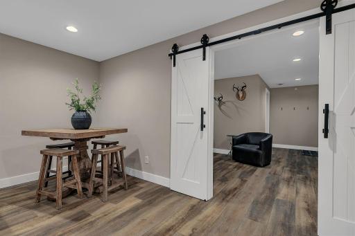 The lower-level living room with plenty of room for a separate area to accommodate a tableâperfect for games, crafts, or extra seating.