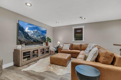 The lower-level living room features an abundance of overhead lighting, keeping the space bright, warm, and inviting.