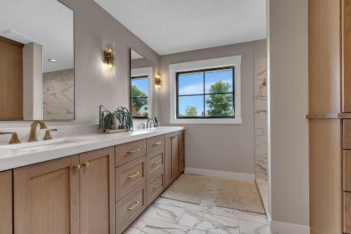 The private primary bathroom with abundant countertop and storage space, offering plenty of room to stay organized while maintaining a clean, stylish look.