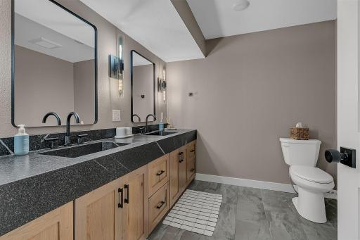 The lower-level bathroom features a beautiful dual vanity and spacious walk-in shower, offering both style and comfort.