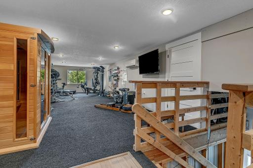 The finished upper level of the outbuilding offers even more space, featuring a full gym and additional living room, all with heating and cooling for year-round comfort.