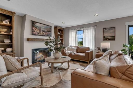 A beautiful living room centered around an electric fireplace and elegant decorative mantel, creating a warm and inviting focal point for relaxing and gathering.