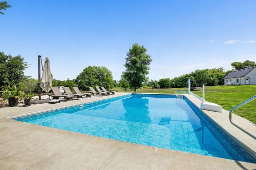 A stunning view of the beautifully landscaped backyard from the pool, showcasing the peaceful setting and inviting outdoor space.