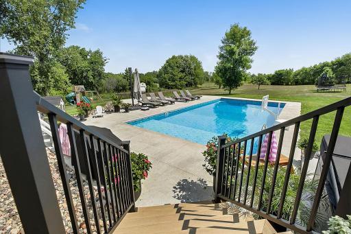 A beautiful view from the deck overlooks the saltwater pool, complete with a spacious sun shelf thatâs perfect for lounging, relaxing, and soaking up the sun.