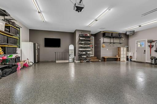 A beautifully finished three-stall garage featuring durable epoxy flooring, heat, and plenty of built-in shelving. With convenient access to both the lower and main levels of the home, this garage is as functional as it is impressive.