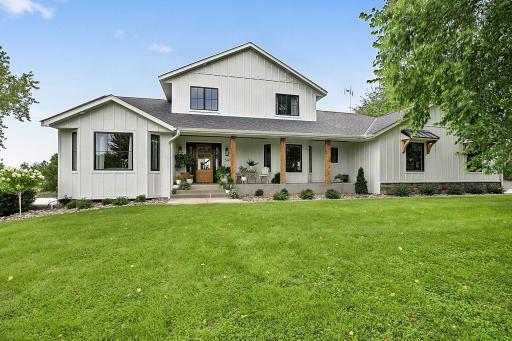 Classic farmhouse charm meets modern style with crisp vertical white siding and striking black windows, creating a clean, timeless exterior with plenty of curb appeal.