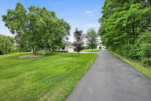 A welcoming view as you approach the home from the driveway, with a convenient layout offering easy access to both the attached three-stall garage and the outbuilding.