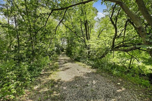 Mowed trails wind throughout the property, providing easy access to enjoy the land, while a gravel path and bridge across the stream make it convenient to explore the back of the property.