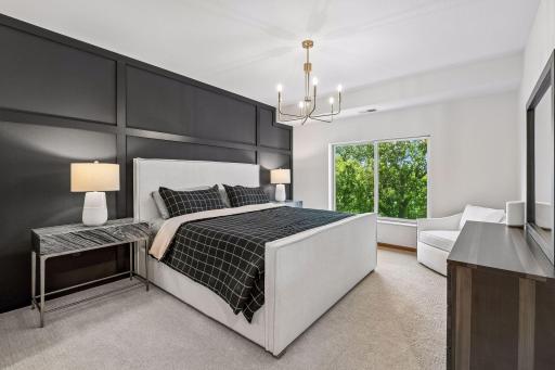 Gorgeous primary suite with stunning architectural paneled wall.