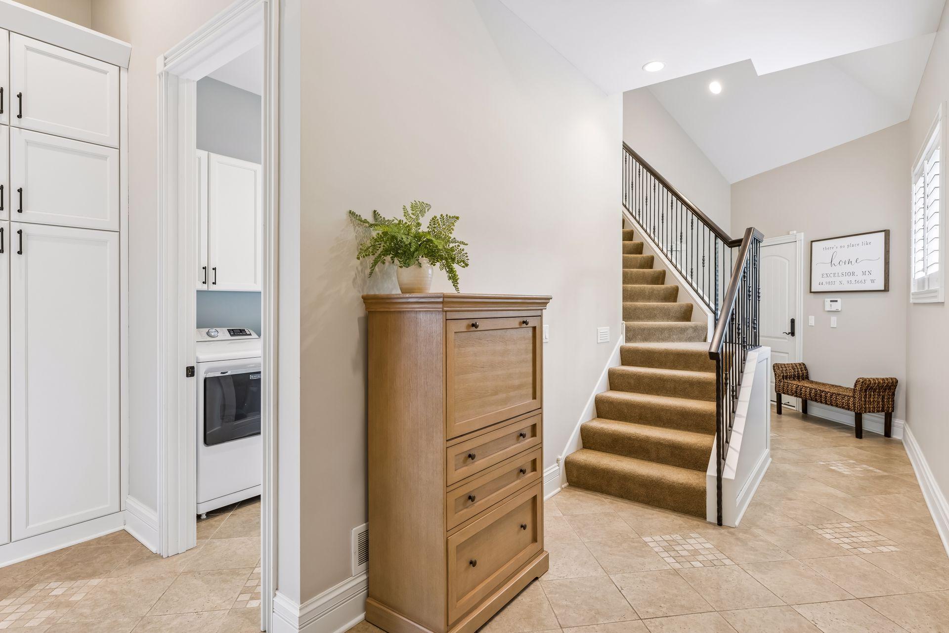 Steps lead up to the bonus room above the garage, with custom storage closets thoughtfully built beneath them near the garage entrance.