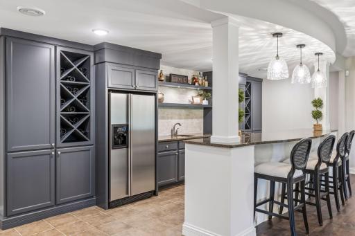 Newly painted cabinets, dedicated wine storage, and tile flooring create a fresh, functional space.
