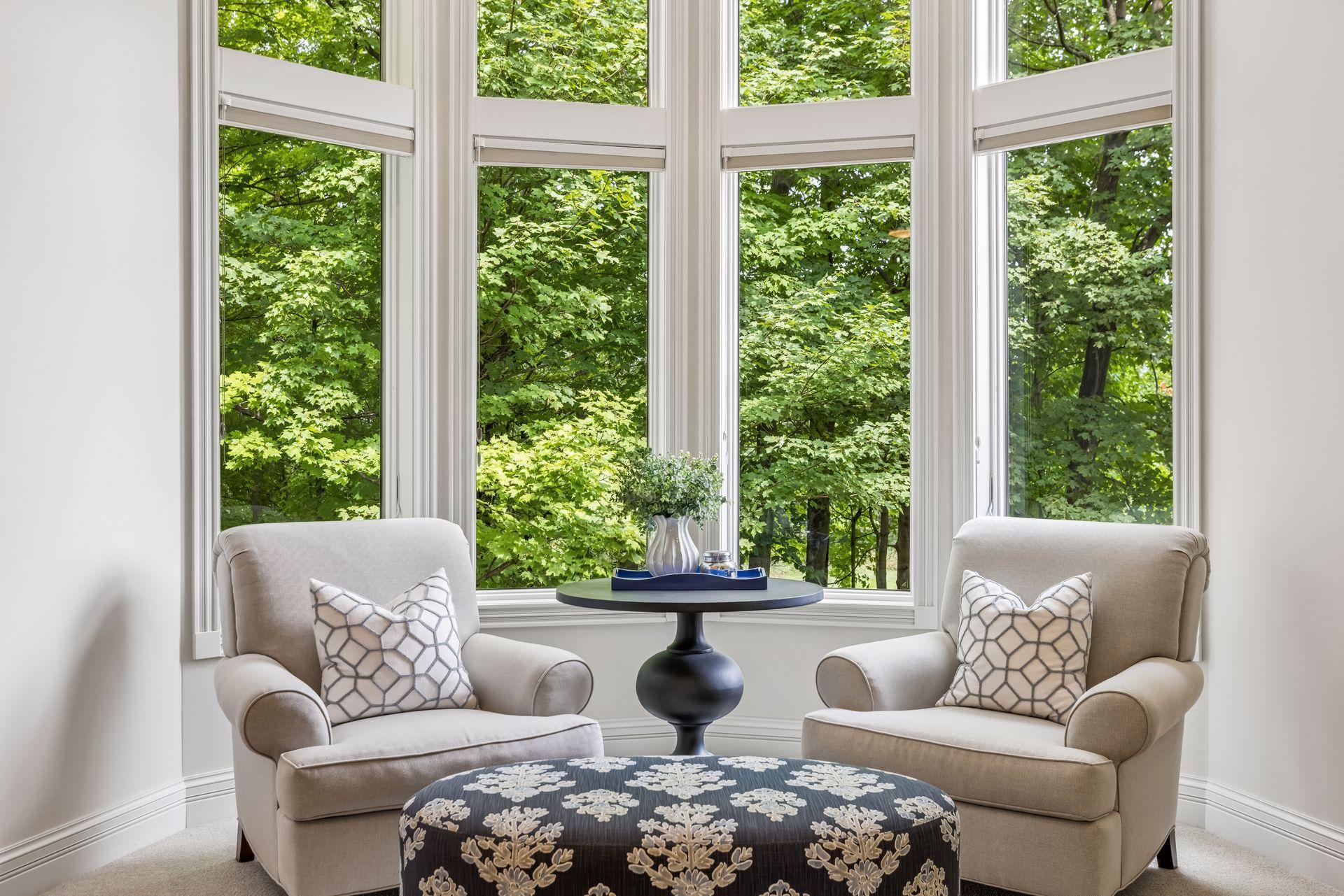An inviting sitting area in the primary bedroom offers peaceful views of the surrounding trees.