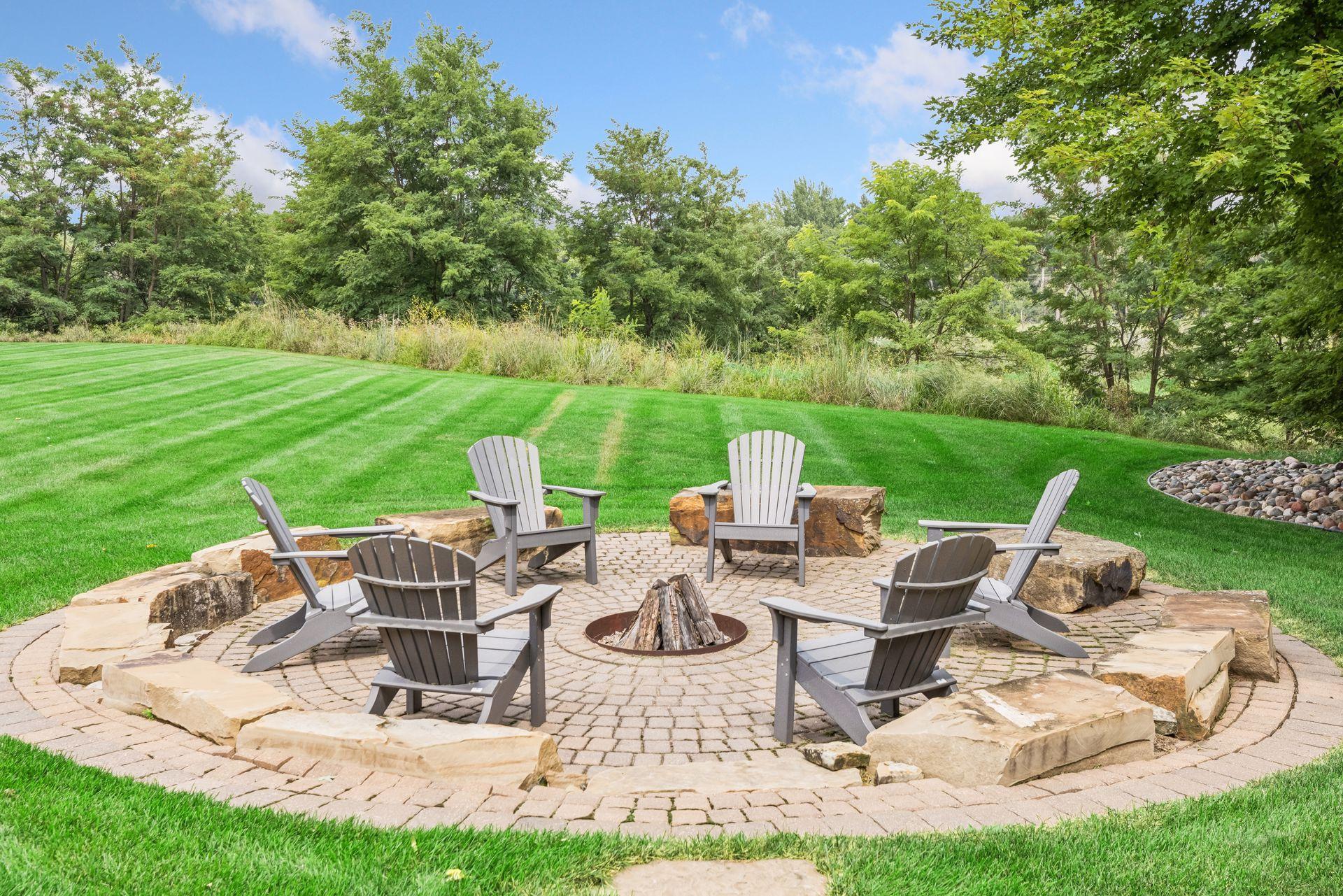 A large, beautifully built firepit nestled among mature trees offers exceptional privacy.