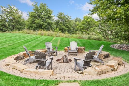 A large, beautifully built firepit nestled among mature trees offers exceptional privacy.
