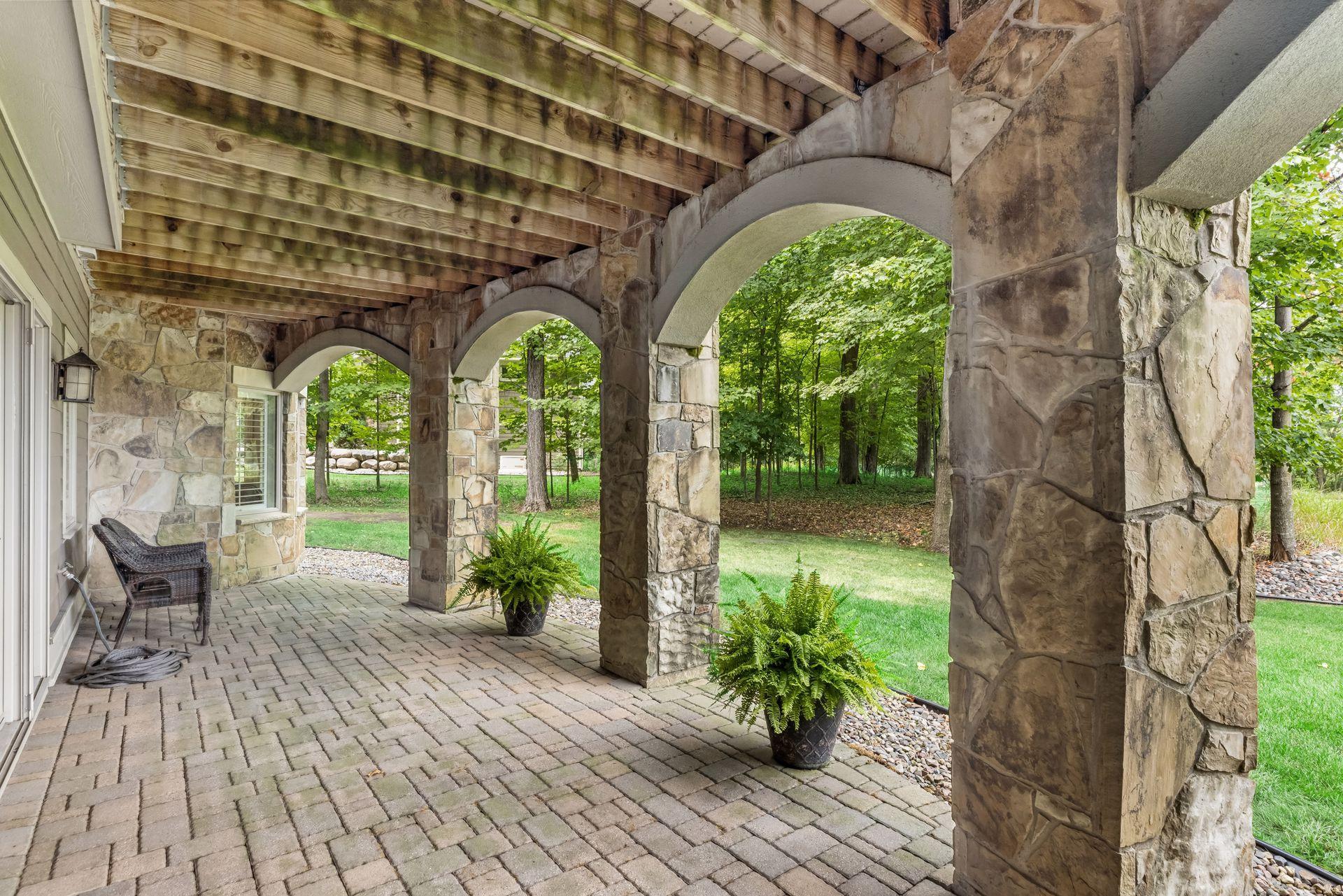 A lower-level patio features beautiful paver stonework for a refined outdoor living space.