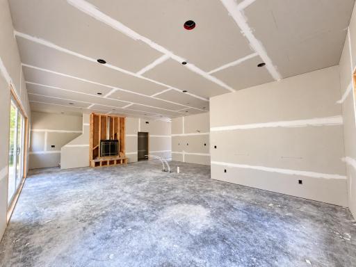Main-level open-concept living and dining area with a partial view of the kitchen and sliding glass door leading to the backyard.