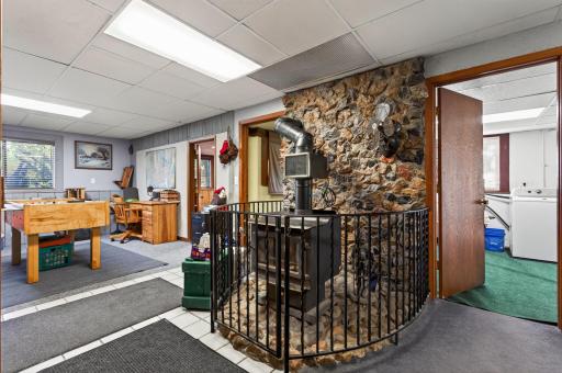 The lower level features a distinctive stone fireplace with a wood burning stove, creating a focal point while adding character to the entire space.