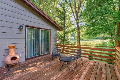 The expansive deck extends the living space outdoors, offering a relaxing spot for al fresco dining, morning coffee, or enjoying the mature trees and surrounding greenery.