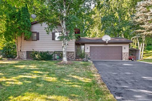 Welcome home to timeless curb appeal, featuring a well-maintained lawn, mature trees, a spacious driveway, and a convenient attached 2 car garage with additional parking on the side.