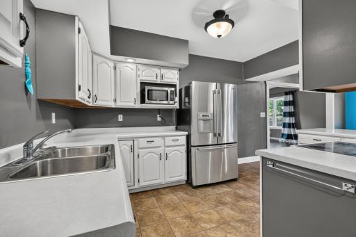 Stainless steel appliances, sink, recessed lighting and spacious pennisula for preparing meals.