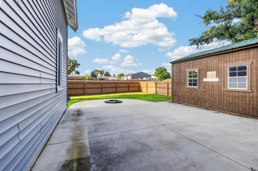 Entertaining 18 x 18 concrete patio nestled in the backyard with plenty of private space for outdoor furniture including a dropped firepit and fenced yard.