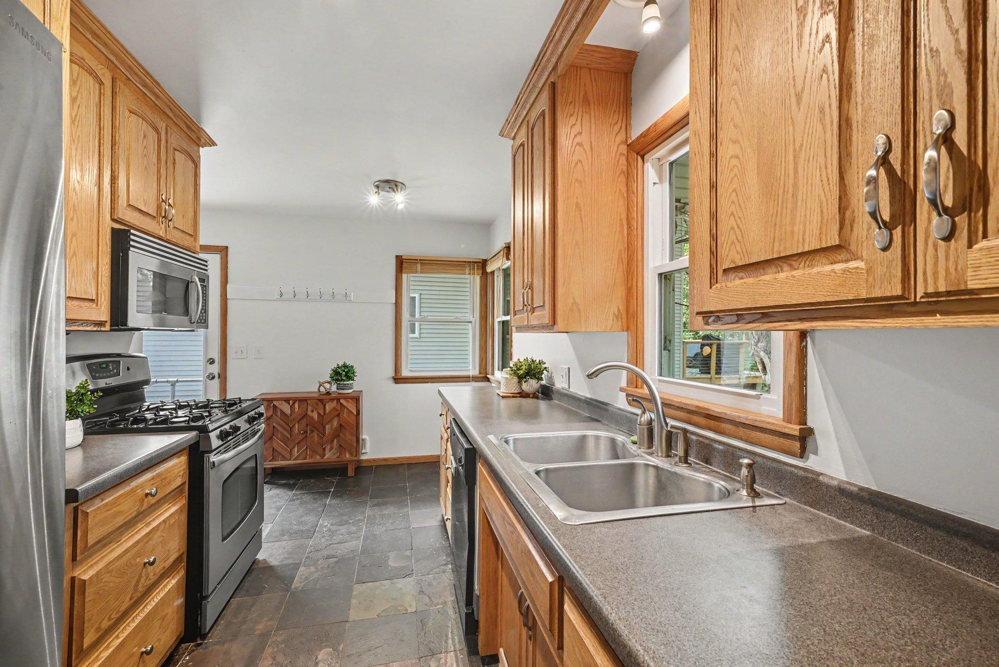 Kitchen with slate floor, plenty of cabinet storage and workspace. Eat in area is large enough for a good sized table.