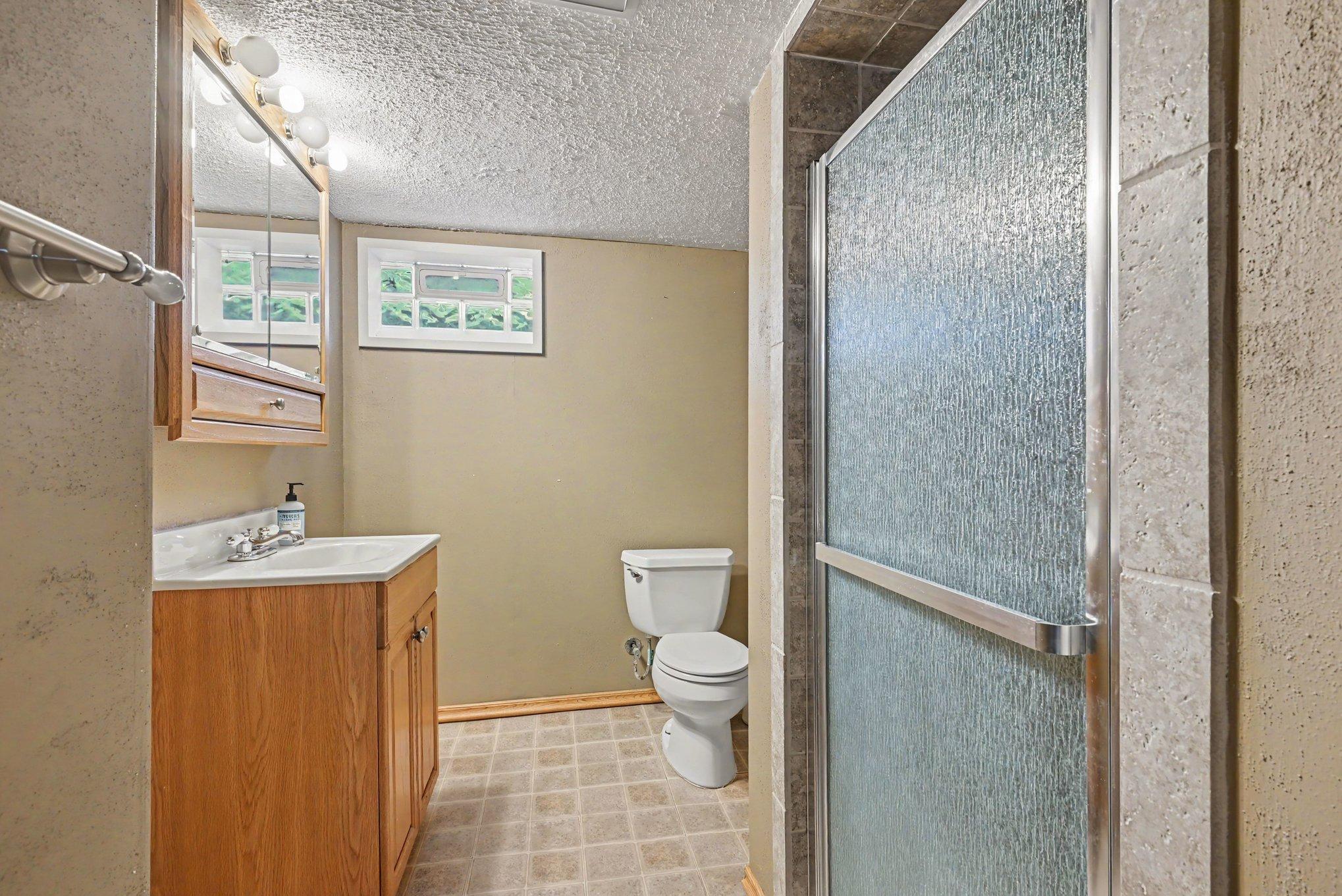 Lower-level 3/4 bath with glass block window
