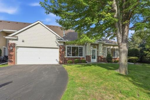 This angle shows off the home's peaceful setting, tucked among mature trees with a curved driveway. Plenty of green space surrounds the property for added privacy.