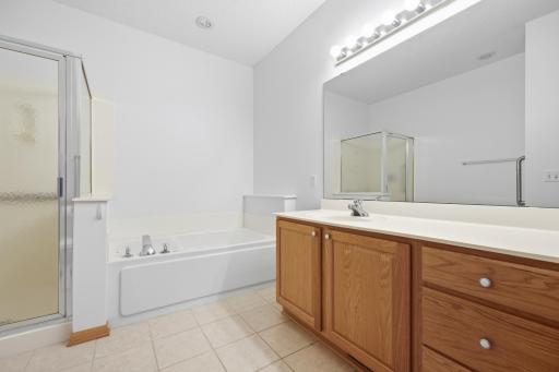 Both the walk in shower and separate soaking tub are showcased here, giving buyers options for their daily routine. A small shelf above the tub adds a nice built in touch.
