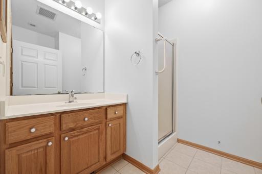 This full second bathroom offers a walk in shower along with a vanity featuring plenty of storage. Tile flooring keeps the space easy to maintain.