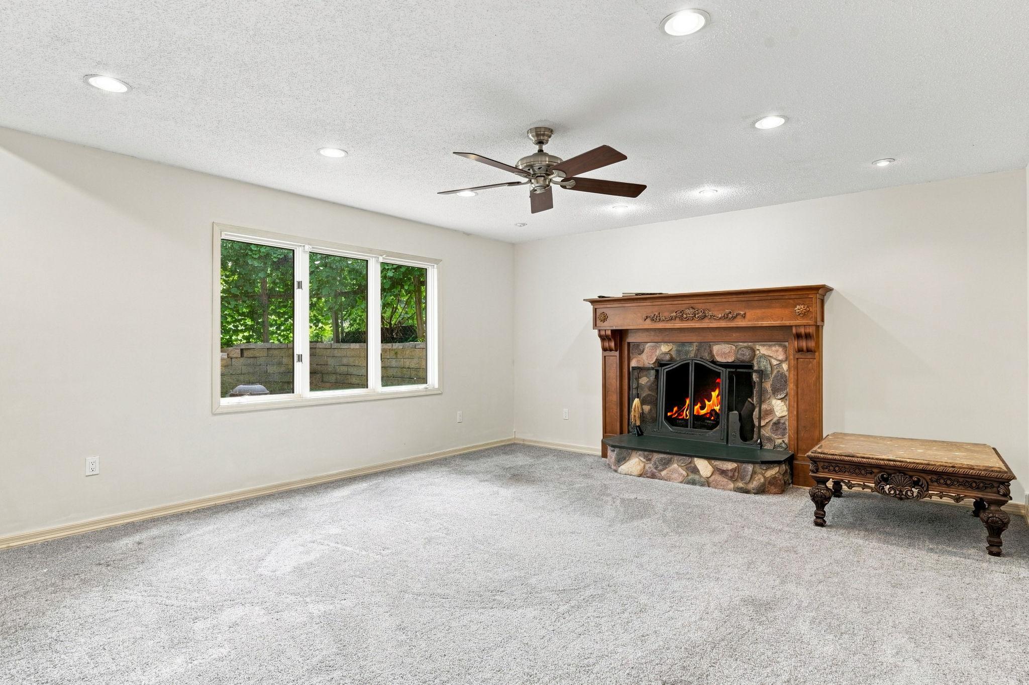 Basement family room with fireplace and backyard views