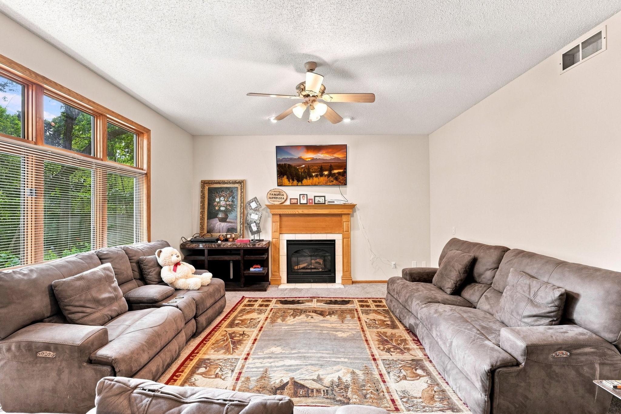 The living room complete with fireplace and is filled with natural light and warmth