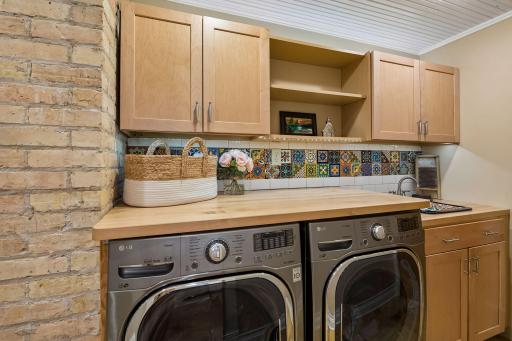 Finished lower level laundry with custom built-in folding space and storage.