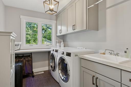 Upper level laundry complete with folding table, sink and storage.