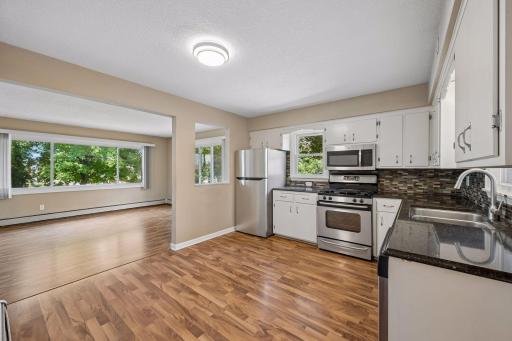 Kitchen features stainless appliances and enamled cabinetry.