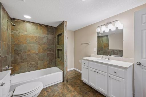 Lower level bathroom with ceramic tile surround