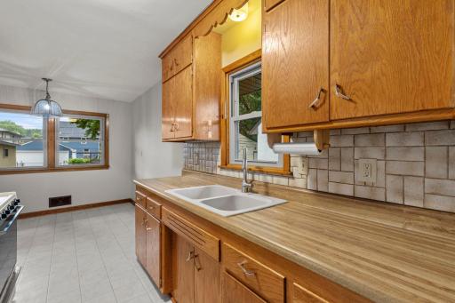 The kitchen flows seamlessly off the main living area, appointed with tile backsplash, and a window overlooking the side yard.
