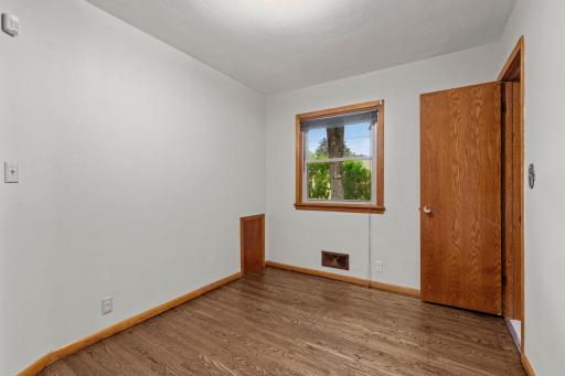 Third bedroom offering backyard views with hardwood floors throughout.