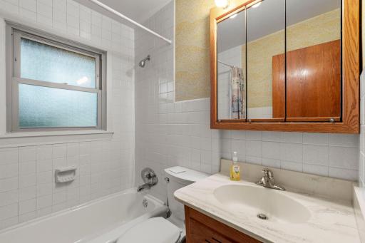 The bathroom features stunning tile half-walls that flow seamlessly throughout.