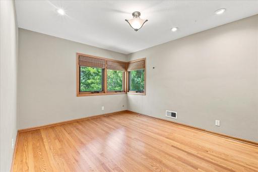 Bedroom 2 on the upper level has a sweeping view of the lush backyard gardens from these corner windows