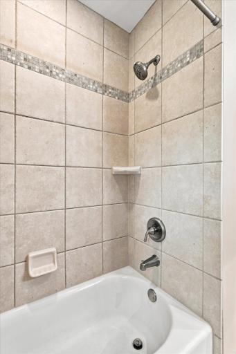 The full bath features a tub with tile surround