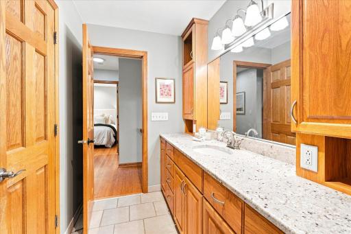 Renovated full bath on the upper level with custom cabinetry and granite vanity top.
