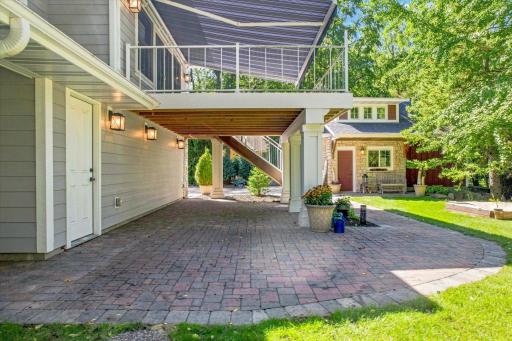 The deck railing above lights up at night over this huge granite paver patio below on the walk out level.
