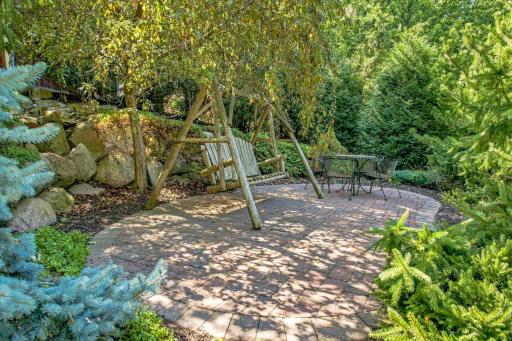 The "swing" patio overlooks the pond and is hidden amongst the trees.