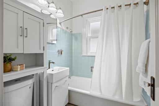 The bathroom features a classic cast iron soaking tub with shower, beautifully accented by spa-inspired tile.