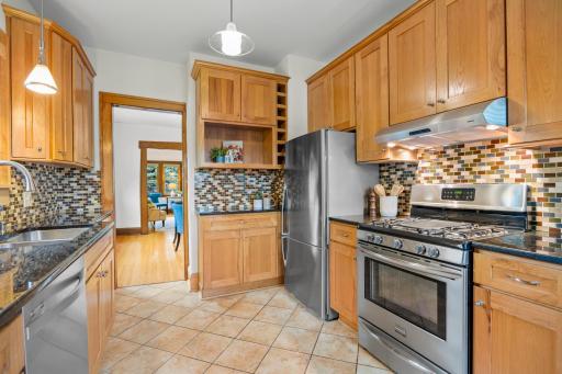 Stunning hickory cabinetry, granite countertops, and a sunny window nook with seating overlooks the serene backyard oasis.