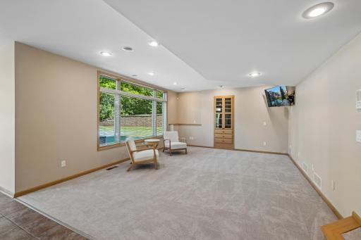 Large family room with build-in speakers and a cabinet for all of your AV components
